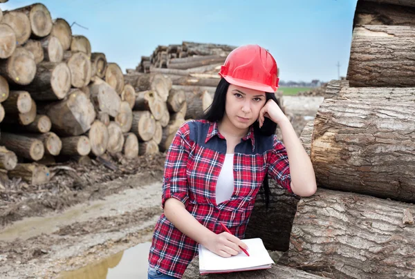 Female forest engineer beside logs — Stock Photo, Image