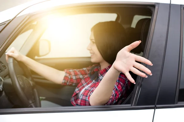 Frau fährt Auto mit Arm aus Fenster — Stockfoto