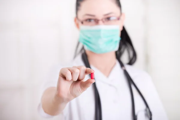 Woman with mask showing pill — Stock Photo, Image