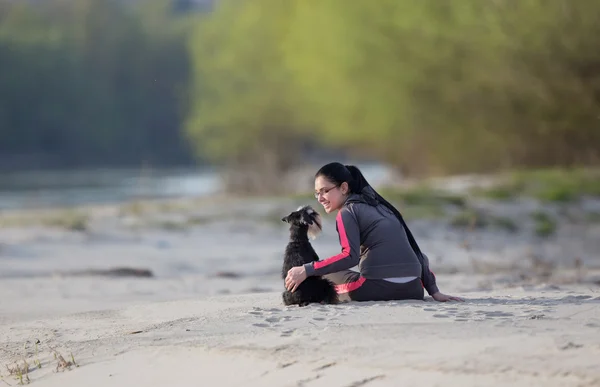 Flicka med hund på sandiga kust — Stockfoto