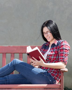 Avluda kitap okuyarak kız