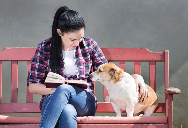 Dziewczyna z psem czytanie książki — Zdjęcie stockowe