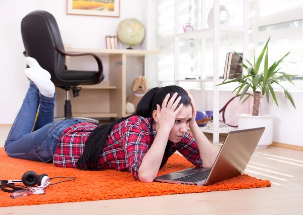 Aufgebrachtes Mädchen schaut auf Laptop — Stockfoto