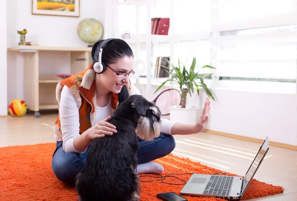 Chica con perro usando videollamada en el portátil — Foto de Stock