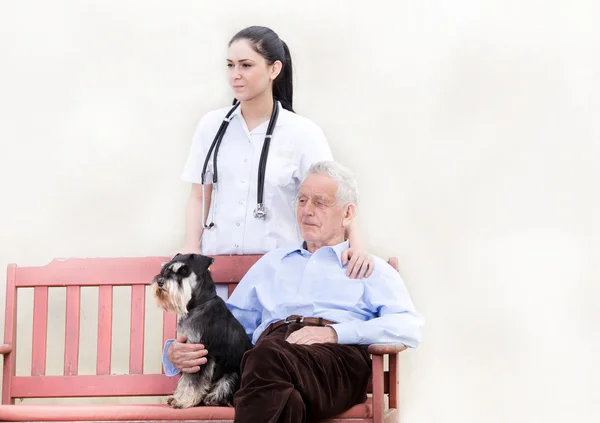 Senior man with caregiver and dog — Stock Photo, Image