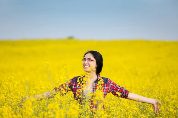 Happy girl in yellow blossom rapeseed field — Stock Photo, Image