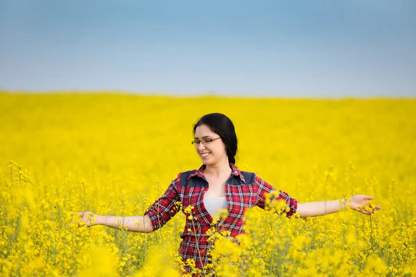Happy girl in yellow blossom rapeseed field — Stok Foto