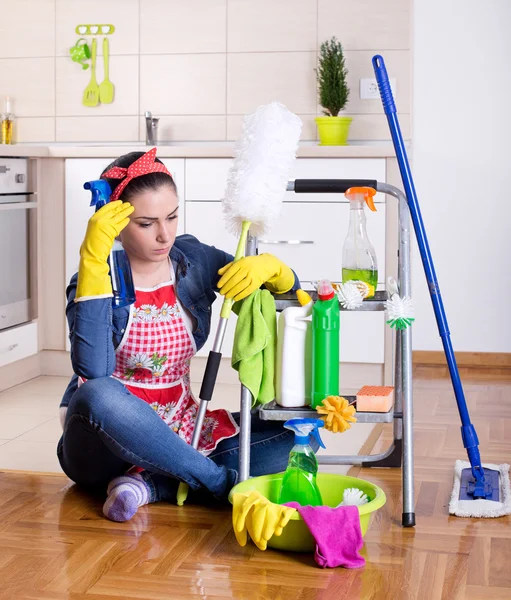 Ongelukkige vrouw met schoonmaak leveringen in de keuken — Stockfoto