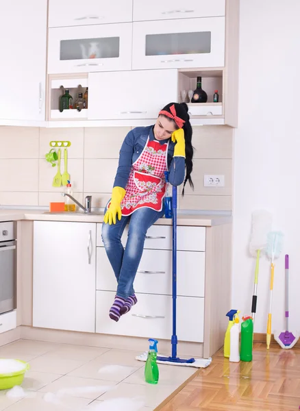 Cleaning lady restng on kitchen countertop