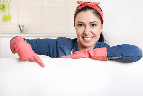 Cleaning lady pointing finger at blank board — Stock Photo, Image