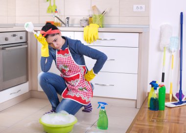 Yorgun ve depresif temizlikçi kadın mutfakta