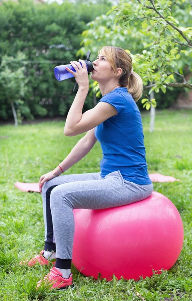 Flicka dricksvatten efter träningen — Stockfoto