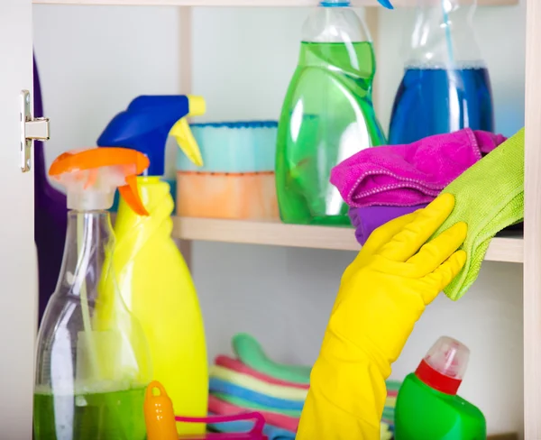 Mulher armazenar ferramentas de limpeza na despensa — Fotografia de Stock
