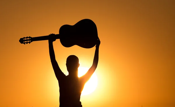 Silhouette di ragazza con chitarra rialzata — Foto Stock