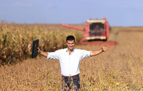 Farmer with combine harvester in soybean field — Stock Photo, Image