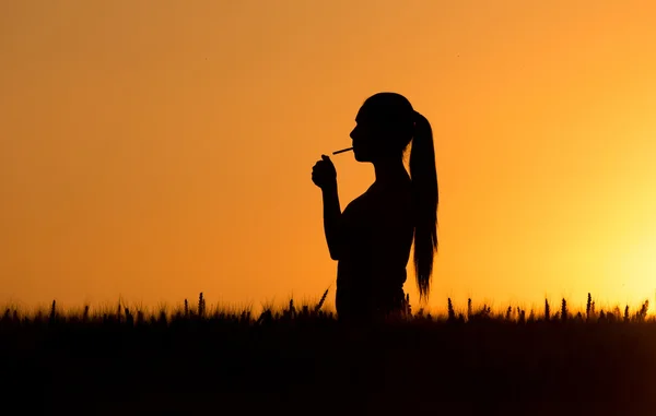 Silhouette di sigaretta illuminazione donna — Foto Stock