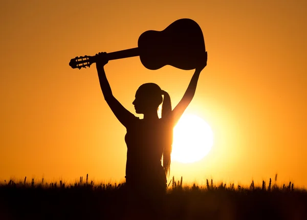 Menina com guitarra ao pôr do sol — Fotografia de Stock