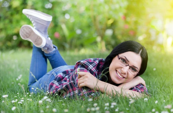 Счастливая молодая женщина лежит на траве — стоковое фото