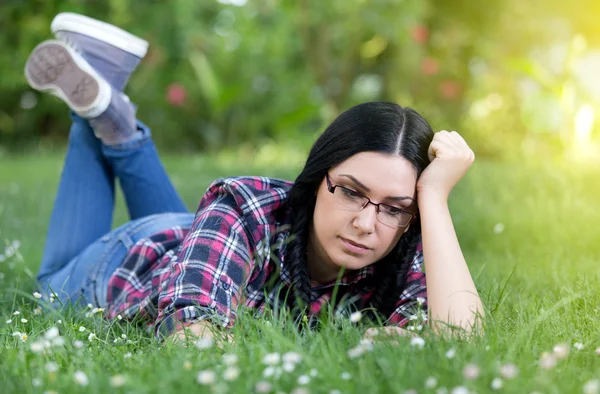 Conceived young woman lying on grass — Stock Photo, Image