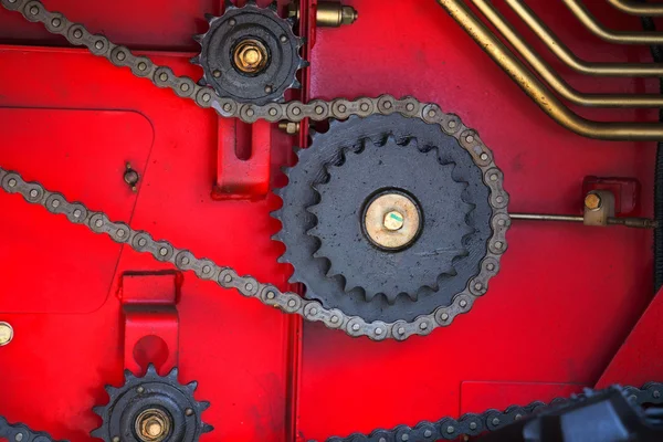 Getriebe und Ketten auf rotem Hintergrund — Stockfoto