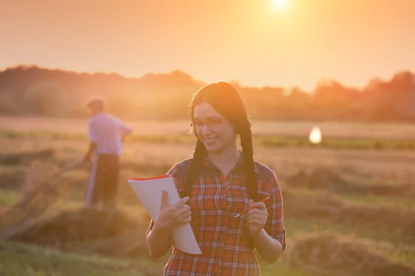 Γεωργός κορίτσι στο πεδίο στο ηλιοβασίλεμα — Φωτογραφία Αρχείου