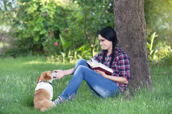 Mädchen mit Hund im Gras, liest ein Buch — Stockfoto