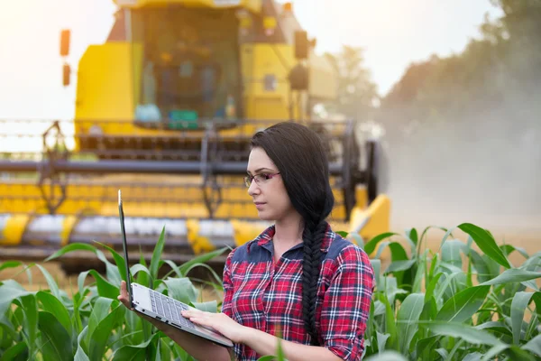 Boer meisje op veld met combineren harvester — Stockfoto