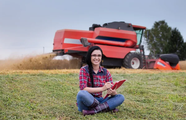 Famer meisje in het veld combineren harvester — Stockfoto