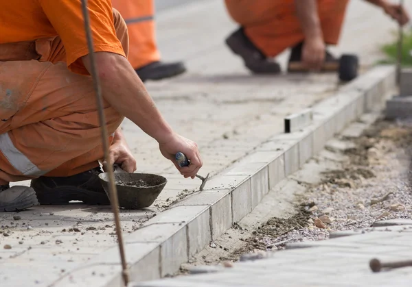 Trabajador instalación bordillo piedras — Foto de Stock