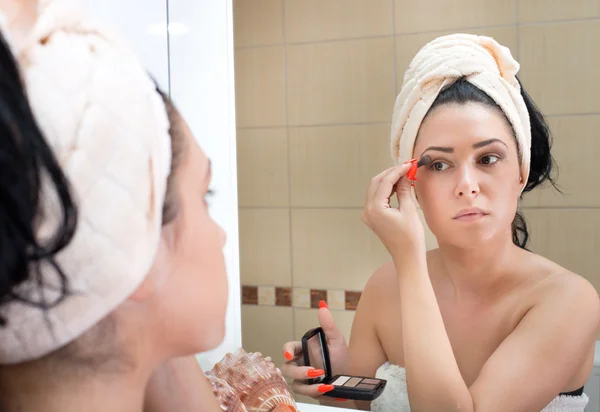 Girl apllying make up in bathroom — Stock Photo, Image