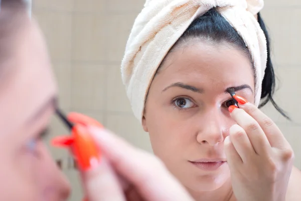 Girl applying makeup on eyebrows — Stock Photo, Image