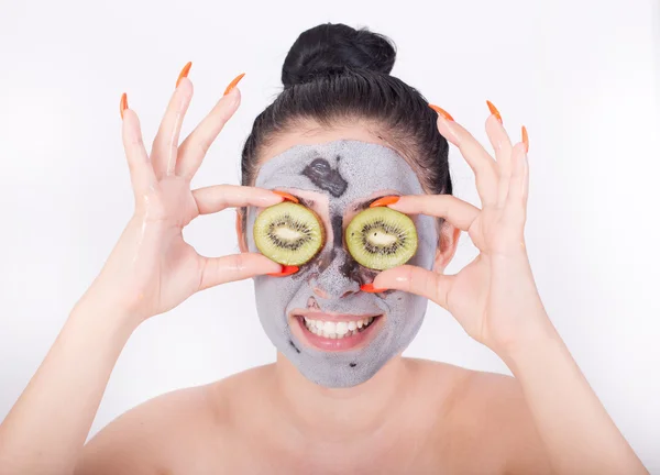 Menina com máscara facial e kiwi — Fotografia de Stock