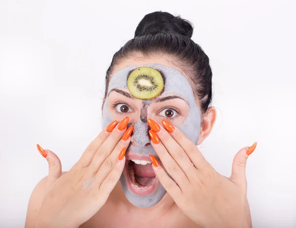 Donna con maschera facciale e fetta di kiwi — Foto Stock