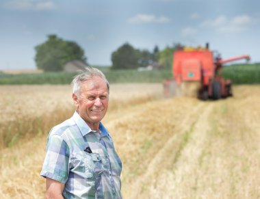 Farmer on field with combine harbester clipart