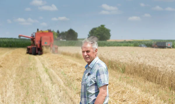 Rolnik na polu z kombajnów harbester — Zdjęcie stockowe