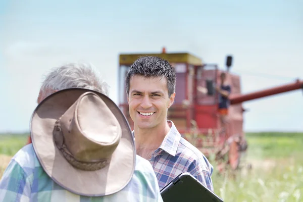 Bauern auf Feld mit Mähdrescher — Stockfoto