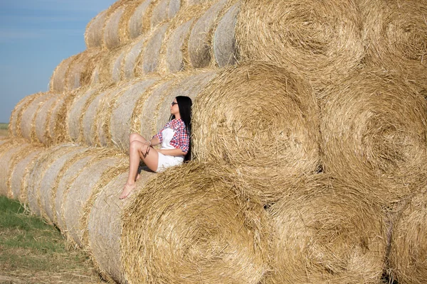 Girl resting on straw bale — Stok fotoğraf