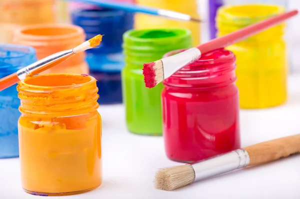 Paint in glass jars and brush — Stock Photo, Image