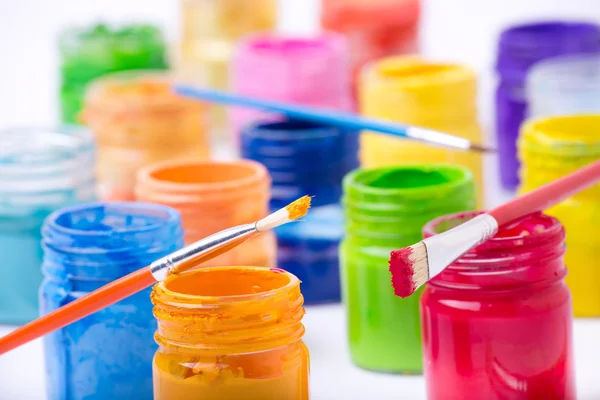 Paint in glass jars and brush — Stock Photo, Image