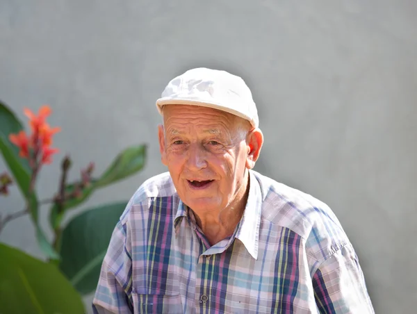 Vieil homme souriant dans la cour — Photo