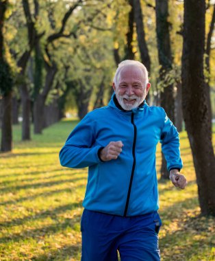 Güneşli bir sonbahar gününde parkta koşan son sınıf öğrencisi. Sağlıklı yaşam tarzı kavramı