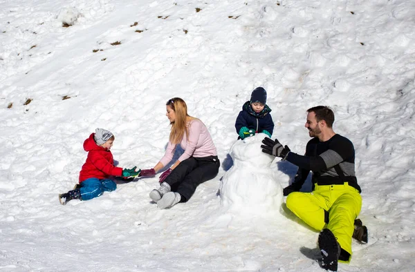 Eltern Mit Zwei Jungen Spielen Auf Schnee Und Basteln Schneemänner — Stockfoto