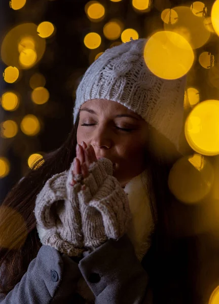 美しいです若いです女の子で冬服の上に祈るクリスマスライト — ストック写真