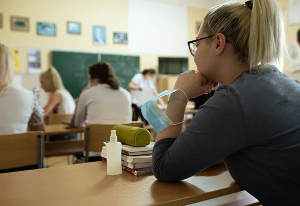 Widok Tyłu Nastolatki Masce Ochronnej Rękę Siedzi Klasie Czasie Pandemii — Zdjęcie stockowe