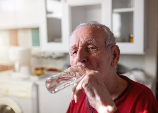 老人はラキアを飲み自宅で強いアルコール飲料 — ストック写真