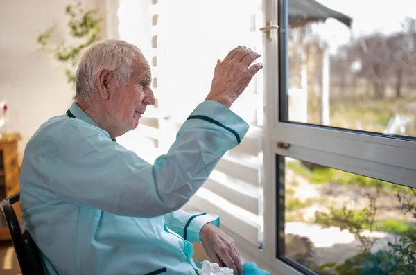 Senior Man Sitting Wheelchair Looking Big Window Waving Hand Greeting — Stock Photo, Image