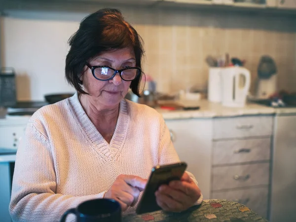 Elderly Woman Sitting Kitchen Surfing Internet Mobile Phone — Stock Photo, Image