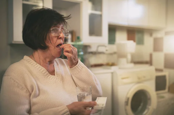 Mujer Mayor Sentada Cocina Bebiendo Pastillas — Foto de Stock