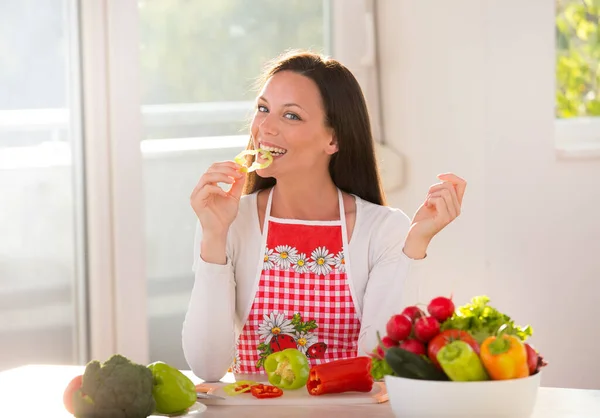 Jovem Feliz Sentada Mesa Com Legumes Tigelas Comendo Fatia Pimenta — Fotografia de Stock