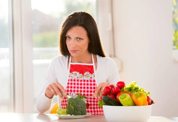 Olycklig Kvinna Skär Broccoli Med Gaffel Och Kniv Vid Köksbordet — Stockfoto